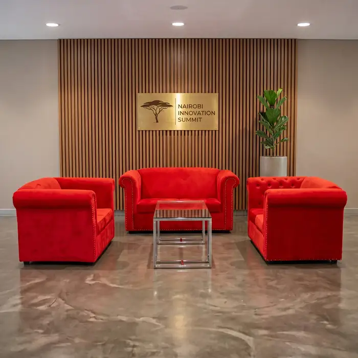 Crimson red velvet two-seater sofa placed in a Nairobi luxury wedding setup with soft lighting and elegant décor